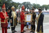 Bupati Konawe, H Yusran Akbar, menerima penghargaan sebagai daerah dengan pengelolaan keuangan terbaik dari Gubernur Sultra, Andi Sumangerukka (ASR), dalam upacara yang digelar di Lapangan Alun-Alun 19 November Kolaka, Minggu (27/4/2025).  
