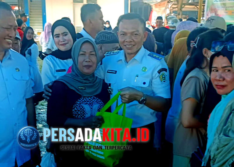 Bupati Konawe, H Yusran Akbar ST menyerahkan paket sembako yang telah dibeli salah seorang warga saat digelarnya Gerakan Pangan Murah di Pasar Asinua, Kabupaten Konawe, Sulawesi Tenggara, Rabu (20/8/2025). Program kolaborasi ini bertujuan untuk pengendalian inflasi secara efektif.