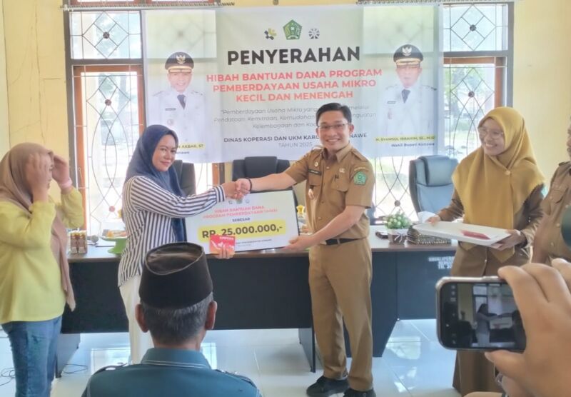 Asisten I Sekretariat Daerah Kabupaten Konawe, Marjuni Ma'mir, menyerahkan secara simbolis dana hibah program pemberdayaan UMKM kepada perwakilan penerima di Kantor Dinas Koperasi dan UMKM, Selasa (23/12/2025).