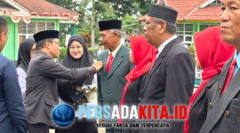 Asisten I Setda Konawe, Marjuni Ma'mir memimpin prosesi penyerahan Satyalancana Karya Satya kepada perwakilan penerima, disaksikan Forkopimda dan ratusan peserta upacara di Lapangan MAN 1 Konawe.
