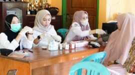 Tenaga kesehatan Puskesmas Anggaberi memeriksa tekanan darah seorang warga dalam kegiatan Cek Kesehatan Gratis di aula Kantor Kelurahan Anggaberi.