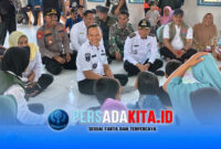 Bupati Konawe, H. Yusran Akbar, ST (tengah berbaju putih) duduk bercengkerama dengan seorang lansia pengungsi banjir di Balai Desa Dawi-Dawi, Kecamatan Wonggeduku, Rabu (13/5/2026). Rombongan kepala OPD, Camat Wonggeduku dan Kapolsek turut mendampingi.