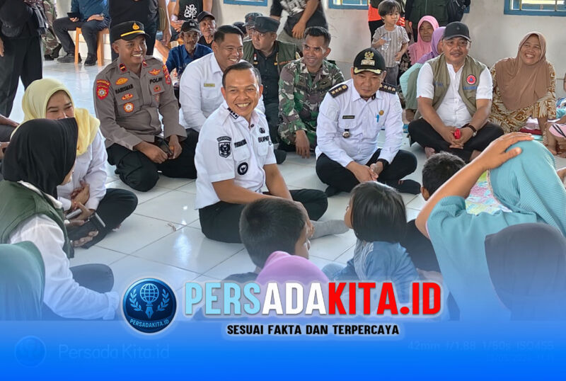 Bupati Konawe, H. Yusran Akbar, ST (tengah berbaju putih) duduk bercengkerama dengan seorang lansia pengungsi banjir di Balai Desa Dawi-Dawi, Kecamatan Wonggeduku, Rabu (13/5/2026). Rombongan kepala OPD, Camat Wonggeduku dan Kapolsek turut mendampingi.
