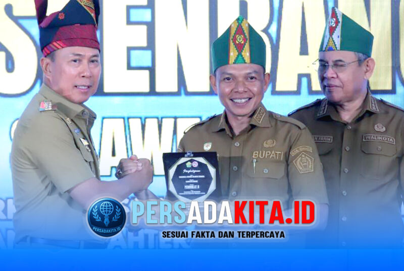 Momen gemilang di ruang Musrenbang Provinsi Sultra. Bupati Konawe, H. Yusran Akbar, S.T. (berdiri di podium), menerima piagam penghargaan Peringkat 2 Aksi Konvergensi Penurunan Stunting 2026 dari Gubernur Sultra, Mayjen TNI (Purn) Andi Sumangerukka. Senyum haru dan bangga terpancar mewakili ratusan ribu warga Konawe, Senin (5/5/2026).