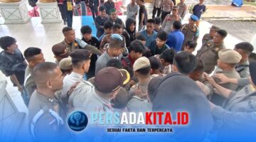 Puluhan mahasiswa HMI Unilaki dan PMII Konawe demo di Kantor Bupati Konawe. Aparat Satpol PP dan Polres Konawe berbaris rapat menghadapi massa demonstran yang mencoba mendekati pintu utama Kantor Bupati Konawe. Suasana tegang namun terkendali.