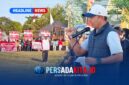 Kapolres Konawe AKBP Edy Raharjono dengan semangat merdeka sebelum memberikan sambutan di atas panggung kehormatan. Suasana tampak khidmat dengan latar belakang bendera merah putih dan panji olahraga.