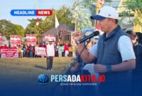Kapolres Konawe AKBP Edy Raharjono dengan semangat merdeka sebelum memberikan sambutan di atas panggung kehormatan. Suasana tampak khidmat dengan latar belakang bendera merah putih dan panji olahraga.