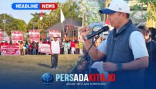 Kapolres Konawe AKBP Edy Raharjono dengan semangat merdeka sebelum memberikan sambutan di atas panggung kehormatan. Suasana tampak khidmat dengan latar belakang bendera merah putih dan panji olahraga.