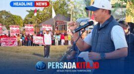 Kapolres Konawe AKBP Edy Raharjono dengan semangat merdeka sebelum memberikan sambutan di atas panggung kehormatan. Suasana tampak khidmat dengan latar belakang bendera merah putih dan panji olahraga.
