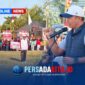Kapolres Konawe AKBP Edy Raharjono dengan semangat merdeka sebelum memberikan sambutan di atas panggung kehormatan. Suasana tampak khidmat dengan latar belakang bendera merah putih dan panji olahraga.