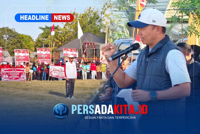 Kapolres Konawe AKBP Edy Raharjono dengan semangat merdeka sebelum memberikan sambutan di atas panggung kehormatan. Suasana tampak khidmat dengan latar belakang bendera merah putih dan panji olahraga.