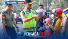 Kapolda Sultra Irjen Pol. Dr. Himawan Bayu Aji, S.H., S.I.K., M.H., memakaikan helm kepada seorang anak yang dibonceng sepeda motor, didampingi personel kepolisian lainnya