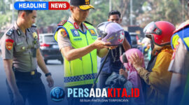 Kapolda Sultra Irjen Pol. Dr. Himawan Bayu Aji, S.H., S.I.K., M.H., memakaikan helm kepada seorang anak yang dibonceng sepeda motor, didampingi personel kepolisian lainnya