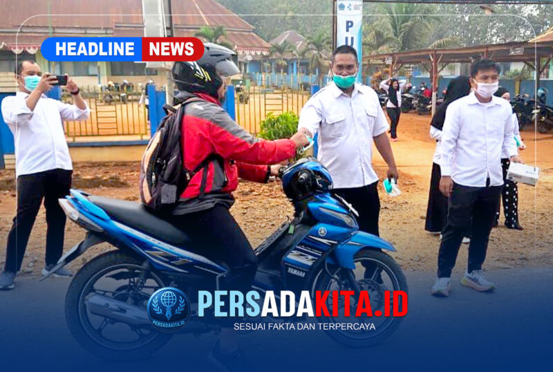 Petugas kesehatan menyerahkan masker secara langsung kepada pengendara sepeda motor sebagai upaya mencegah paparan ISPA akibat kabut asap yang melanda Kecamatan Puriala.